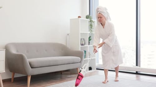 Lady After Shower Hoovering Studio Room with Stick Vacuum