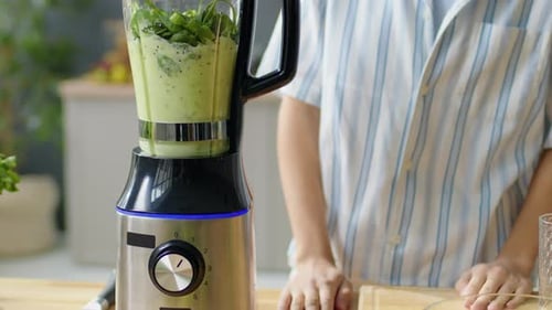 Woman Preparing Green Smoothie in Blender