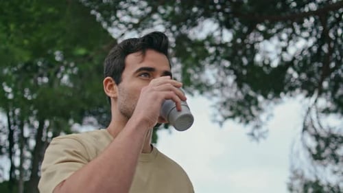 Man Drinking from Reusable Cup Outdoors