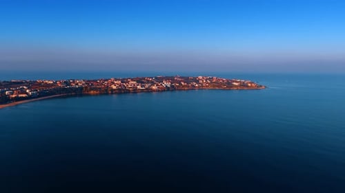 Multiple houses located on the spit surrounded by the beautiful dark blue waterscape.