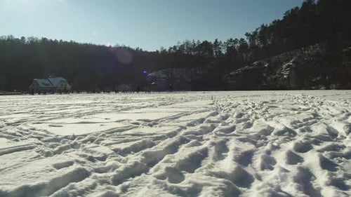 Large frozen Harasov lake imprinted by ice skating tracks and footprints in Kokorin, Czech Republic