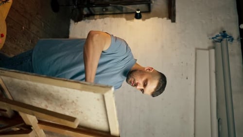 in an Art Workshop an Artist in Blue Tshirt is Actively Drawing on Canvas