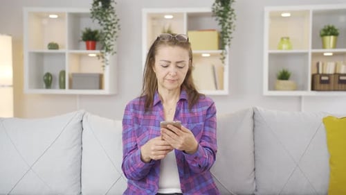 Woman laughing at phone message.