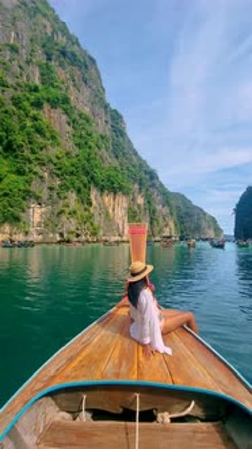 Asian Women in Front of Longtail Boat with Green Blue Turqouse Lagoon at Koh Phi Phi Thailand