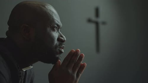 African American Priest Praying to God in Church