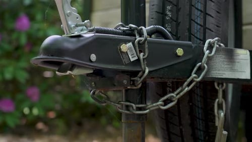 Camera moving up to show the coupler and jack of a trailer.