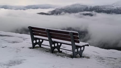 Snow-Covered Bench Overlooking a Foggy Mountain Valley in Portugal at High Altitude