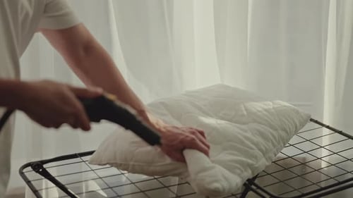 Steaming White Pillow on Rack for Cleaning
