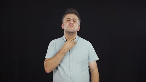 Man Experiencing Throat Irritation on Black Background