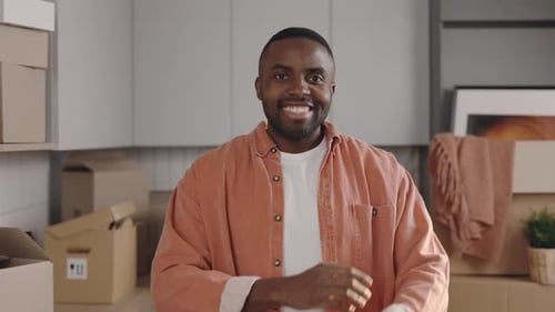 Man Smiling Indoors With Moving Boxes