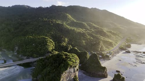 Panoramic Mountain Landscape Over Ocean with Sunlit Hills and River West Coast New Zealand Travel