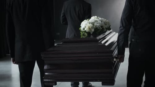 Pallbearers Carrying Casket With Flowers