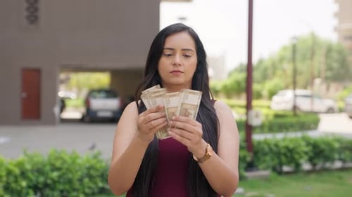 Young Woman Counting Money in a Suburban Setting
