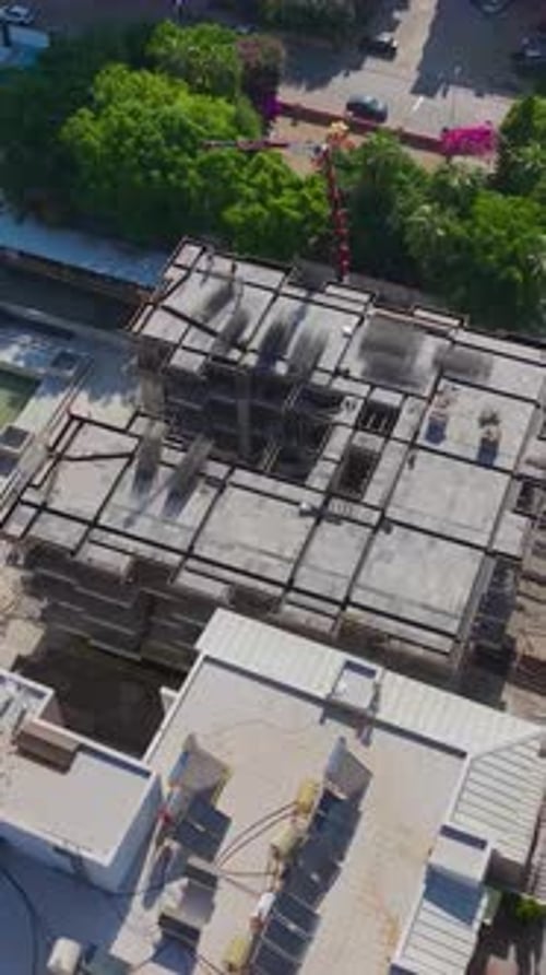 Vertical Video Workers on a Construction Site Handling Metal and Installing Facades with Stone