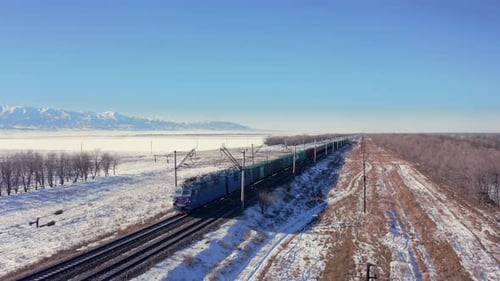 Luftaufnahme, Eisenbahnzug mit Zug und Güterwagen fährt in der Steppe