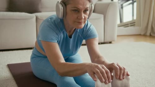 Senior Woman Stretching on Yoga Mat at Home