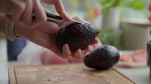 Woman Cuts Avocado for Healthy Meal at Home