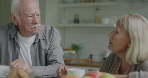 Senior Couple Talking at Kitchen Table