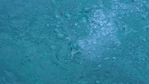 Clear Water Stream Flowing Into a Teal Pool