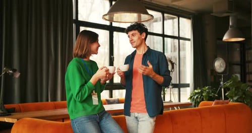 Man and Woman Drinking Coffee in Modern Office