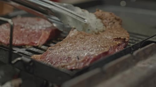 Cooking Beef Steaks on BBQ Grill Outdoors