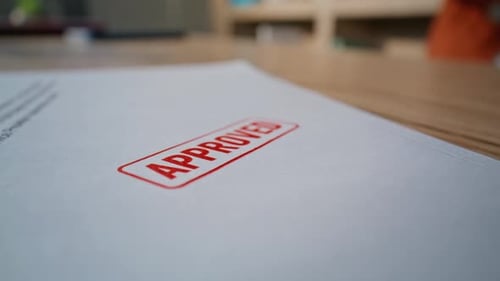 Closeup Legal Document Stamped By Unknown Lawyer Hand in Professional Office
