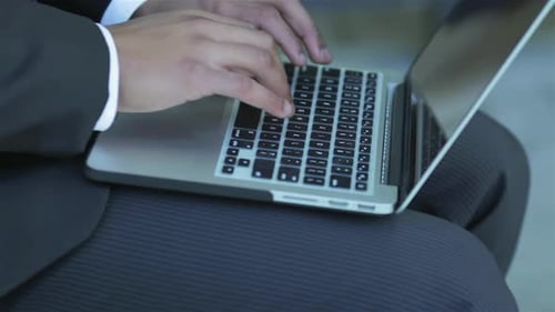 Man in Suit Typing on Laptop Keyboard Close Up