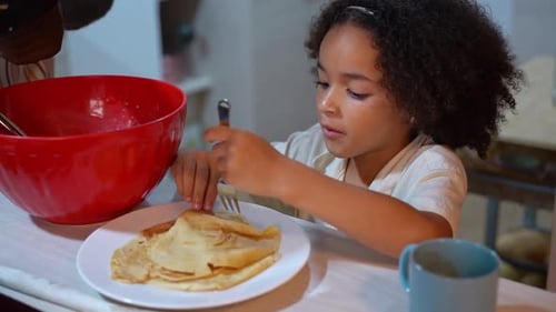African American Funny Daughter Girl Taste Eat Pancakes While Multiethnic Family Cooking Pancakes
