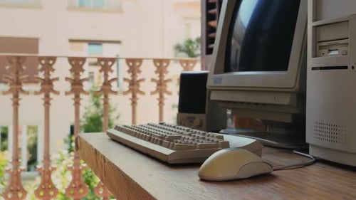 Hombre trabajando y jugando en una computadora retro, ingeniero de TI con una computadora antigua en casa usando una vieja