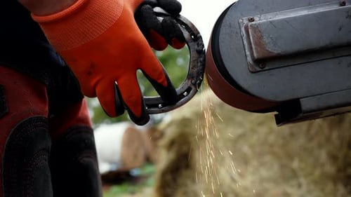 Horseshoe Being Ground Down on Machine