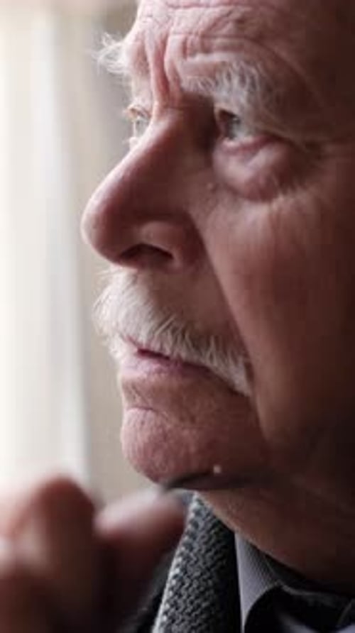 Elderly Man Looking Out Window in Close Up