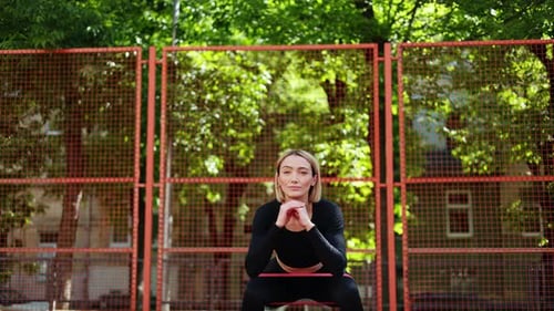 Athletic Woman Doing Squats with Resistance Band
