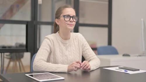 Pensive Young Woman Sitting in Office