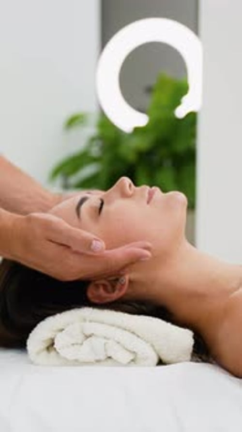 Spa-Therapeut bietet einer Frau eine verjüngende Gesichtsmassage