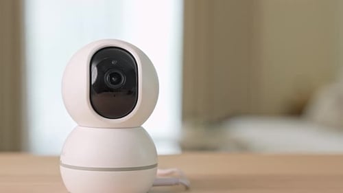 A home security camera tilting upward.