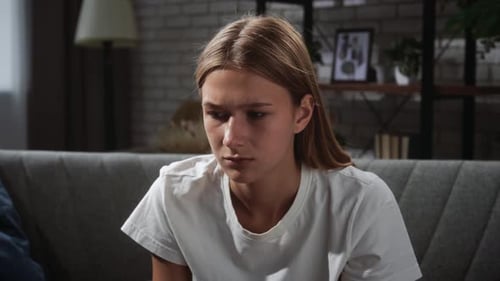 Young Woman in Thoughtful Pose on Comfortable Sofa