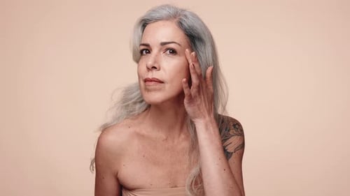 Mature Woman Applying Cream to Face