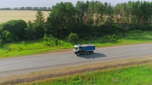 Flight Over the Straight Road with Driving Truck on a Sunny Summer Day