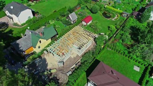 Aerial View Of House Construction With Unfinished Roofing Works In A Neighborhood. orbiting