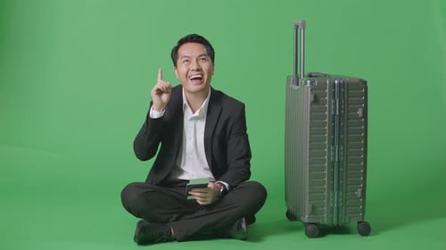 Businessman With Luggage Thinking Then Raising Her Index Finger While Sitting In The Green Screen