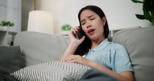 Young Adult Talking on Phone on Couch Indoors
