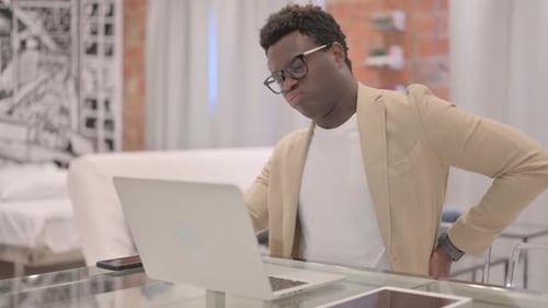 Young Man Experiencing Back Pain While Working
