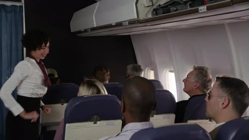 Flight Attendant Secures Overhead Bin in Airplane Cabin