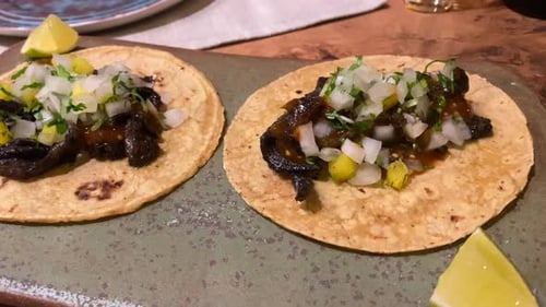 Two Delicious Tacos with Lime at Restaurant