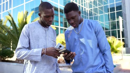 Young Men Using Mobile Phones in Urban Setting