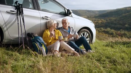 Senior Couple Relaxing After Hike in Rural Landscape