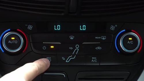 Finger presses button for turning on maximum airflow on the multimedia panel of car, two-phase