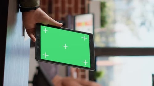 Adult Holding Tablet with Green Screen Indoors