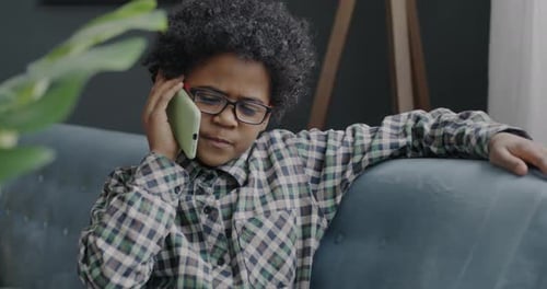 Boy Chatting on Cell Phone Relaxing on Sofa