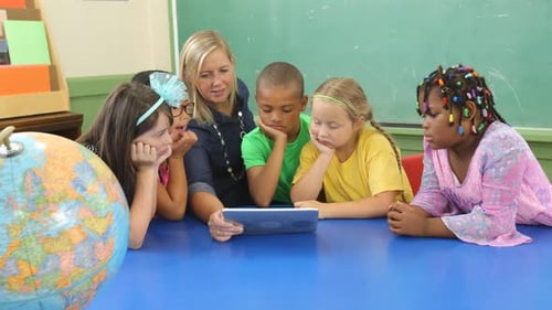 Enthusiastic teacher using tablet with diverse students